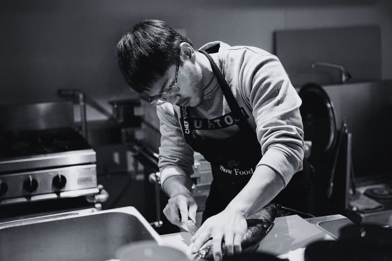 Two chefs plating side by side